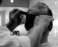 A barber hairstyling a man