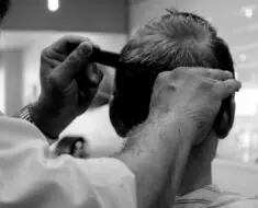 A barber hairstyling a man