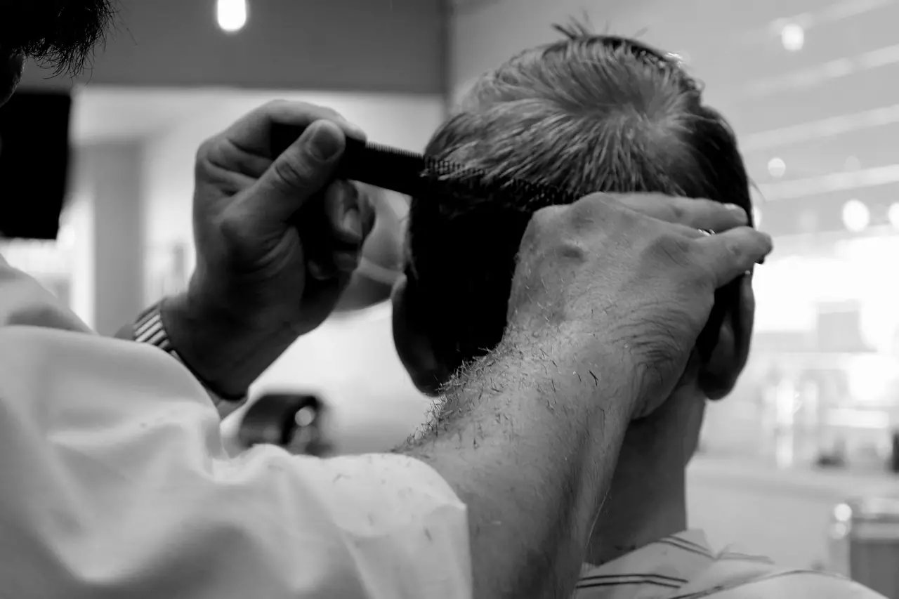 A barber hairstyling a man
